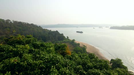 from-Reis-Magos-Church-fort-goa-India-reviling-drone-shot-cocoa-beach-Panjim-goa-cinematic-shot-India-Panji-bridge-Mandovi-river-ship-passing-by-sand