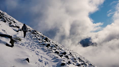 Rear-shot-of-person-hiking-on-snowy-mountain-of-Kepler-Track-in-New-Zealand