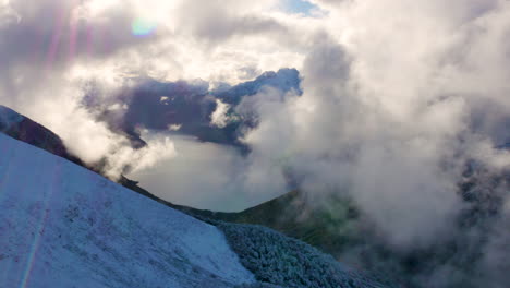 Luftaufnahme-Von-Schneebedeckten-Bergen-Mit-Fliegenden-Wolken-Und-Ruhigem-See-Im-Tal-Des-Fiordland-Nationalparks-In-Neuseeland