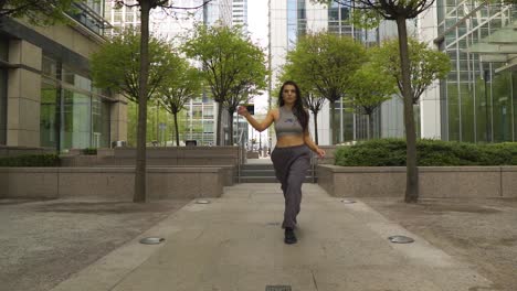 Very-confident-female-urban-street-dancer-cat-walking-towards-the-camera-with-attitude-dominating-her-space-face-expressions-on-point-slow-motion-high-towers-park-metropolis