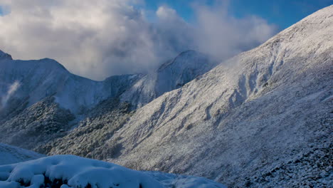 Schwenkschuss-Auf-Wunderschöne-Schneebedeckte-Berge,-Umgeben-Von-Wolken-Im-Sonnenlicht-Beim-Wandern-Auf-Dem-Kepler-Track-In-Neuseeland