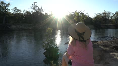 Blonde-woman-sitting-on-rivers-edge-sunset-Australian-fauna-camping