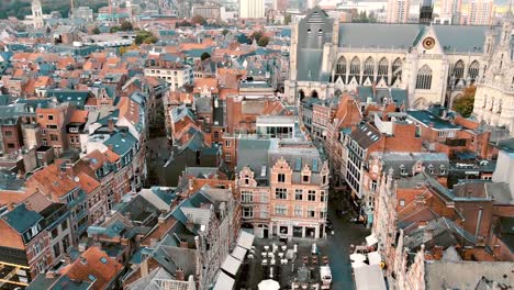 Fly-over-Oude-Markt-Square-reveal-Saint-Peter's-Church,-Belgium-Leuven