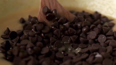 Makro-Nahaufnahme-Des-Gießens-Von-Schokoladenstückchen-In-Eine-Schüssel-Mit-Zutaten