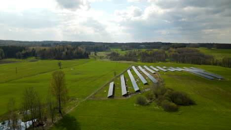 Toma-Aérea-De-Unidades-Solares-Fotovoltaicas-Que-Producen-Energía-Renovable-Durante-El-Día-Soleado-En-La-Naturaleza