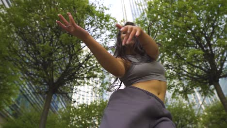 Funky-street-dancer-with-great-body-physique-freestyle-outdoor-keep-on-smiling-enjoying-her-movements-in-the-middle-of-London-with-tall-buildings-slow-motion