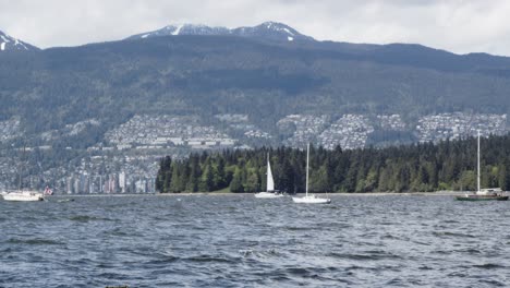 Waves-passing-vancouver-False-Creek-inlet,-stanley-park,-west-vancouver-and-sail-boats