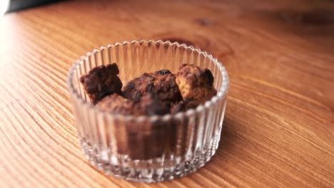 closeup-of-putting-overcooked-burnt-chocolate-chip-cookie-in-glass-jar