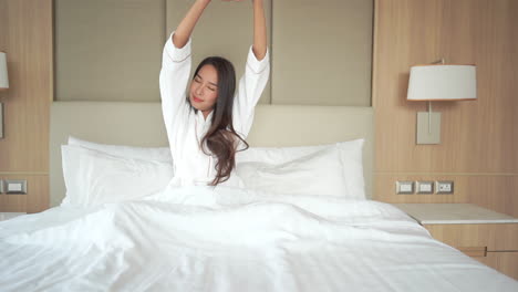 Schöne-Asiatische-Frau,-Die-Im-Bett-Aufwacht-Und-Arme-Slomo-Ausdehnt