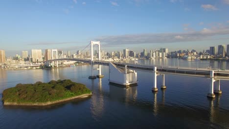 Aerial-View-Of-Rainbow-Bridge-Crossing-Tokyo-Bay-With-Cityscape-Of-Tokyo,-Japan
