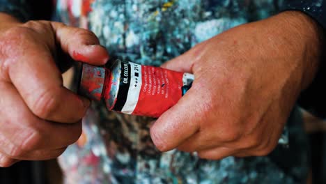 Artist-Painter-opening-the-tube-of-red-paint