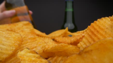Moving-forward-view-of-person-eating-chips-and-drinking-beer