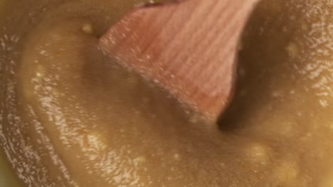 Closeup-macro-of-wooden-spatula-mixing-delicious-paste-ingredient,-slomo