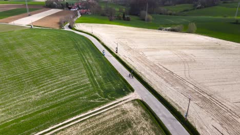 Luftaufnahme-Mit-Radfahrern,-Die-An-Einem-Bewölkten-Tag-Ihren-Radurlaub-Zwischen-Belgischen-Landwirtschaftlichen-Feldern-Genießen