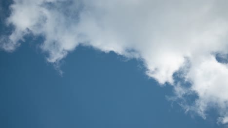 Nubes-Esponjosas-Blancas-En-Movimiento-Rápido-Aisladas-En-El-Cielo-Azul,-Vista-Estática