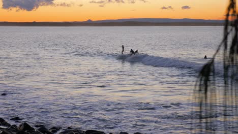 Gente-Surfeando-Durante-La-Hora-Dorada-En-El-Parque-Nacional-De-Noosa-En-Queensland,-Australia