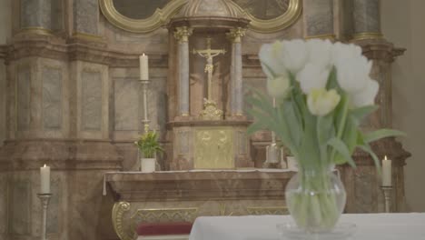 Flower-vase-with-white-tulips-on-an-altar-in-front-of-a-baroque-chancel