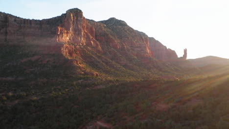 Aerial:-rock-mountain-valley-with-forest-in-sunlight-at-Sedona,-Arizona---drone-flying-forward