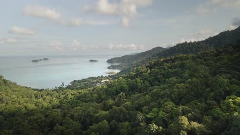 Aerial-flyover-of-dense-tropical-forest-with-ocean-and-island-coastline-Koh-Chang