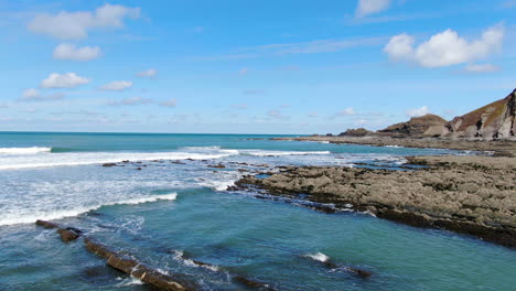 coastal-drone-footage-of-waves-crashing-into-rocks-over-the-devon-coastline-in-the-UK