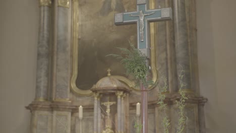 Kameraschwenks-Zu-Einem-Kreuz-Im-Altarraum-Einer-Kirche-Mit-Barockem-Altar-Im-Hintergrund