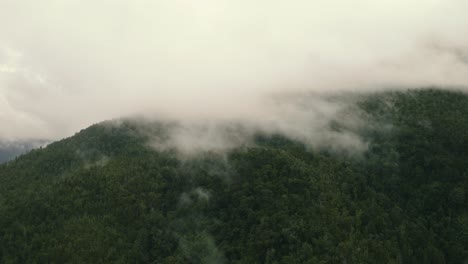 Aus-Der-Luft-Herauszoomende-Und-Umkreisende-Aufnahme-Eines-Berges,-Der-Mit-Nebel-Und-Wolken-Bedeckt-Ist,-An-Der-Westküste-Neuseelands