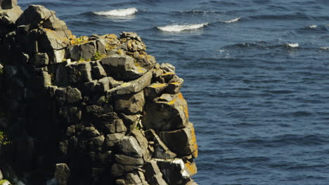 Pan-up-detail-shot-of-the-layers-of-Basalt-in-the-Hvitserkur-sea-stack-in-Iceland