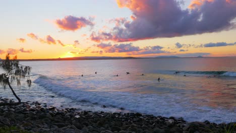 Menschen-Reiten-Die-Großen-Wellen-Während-Des-Sonnenuntergangs-Am-Strand-Im-Australischen-Bundesstaat-Queensland