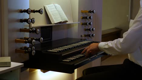 A-man-plays-on-an-organ-with-two-manuals