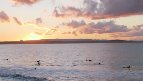 Group-Of-Surfers-Enjoys-The-Ocean-Waves-With-A-View-Of-Sunset-At-The-Beach-In-Noosa-National-Park