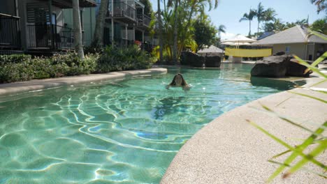 Mujer-Caucásica-Nadando-Sola-En-La-Piscina-Al-Aire-Libre-Del-Resort-De-Vacaciones-En-Verano