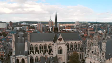 Fly-over-pan-across-Leuven-Saint-Peter's-Church-to-Town-Hall,-Belgium