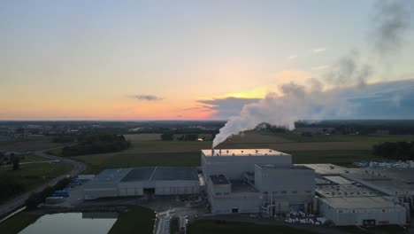 Fliegen-In-Richtung-Einer-Fabrik-Mit-Einem-Wunderschönen-Sonnenuntergang-Im-Hintergrund