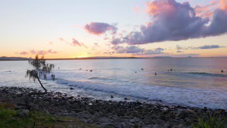 Surfer-Und-Touristen-Schwimmen-Am-Strand-In-Noosa-Heads,-Australien-Bei-Einem-Sonnenuntergang