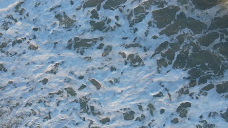 Uae:-Luftaufnahme-Von-Wellenbrüchen-Am-Strand,-Vogelperspektive-Von-Meereswellen,-Die-Gegen-Das-Leere-Ufer-Schlagen-Und-Schäumen,-Rauer-Meerblick