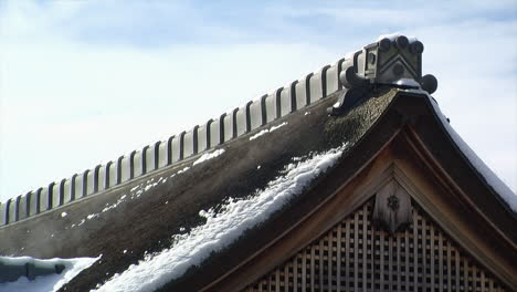 Roof-peak-of-Japanese-house-with-melting-snow-giving-off-mist