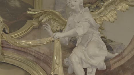 Camera-pans-to-the-sculpture-of-a-white-angel-with-golden-wings-on-a-baroque-altar