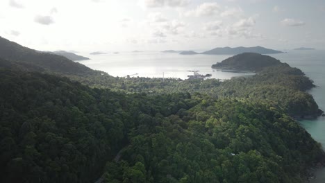 Aerial-footage-of-Island-coastline-with-tropical-forest-and-ocean-at-sunrise