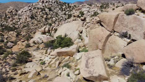 Side-drone-flying-in-rocky-desert-with-stone-boulders