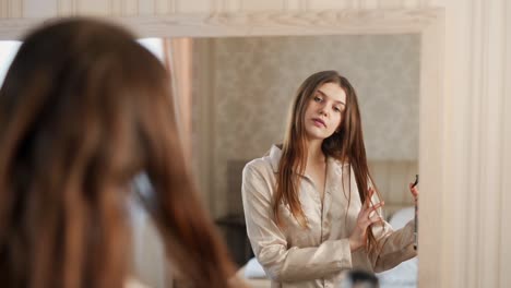 Close-up-portrait-of-a-young-beautiful-woman-in-the-mirror-applies-hair-spray