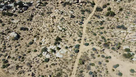Flying-over-small-desert-house-and-revealing-majestic-desert-terrain