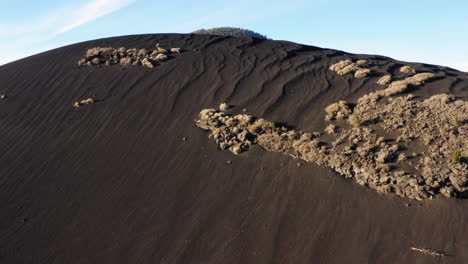 Schwarze-Sanddüne-Mit-Vulkanberg-Bei-Sonnenuntergang-Krater,-Fahnenmast---Drohnenflugaufnahme