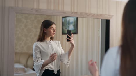 Porträt-Einer-Schönen-Frau-Im-Spiegel,-Die-Fotos-Auf-Einem-Smartphone-Macht