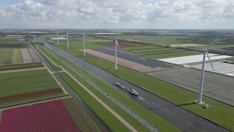 Sunny-day-at-countryside-of-Netherlands-with-canal-and-windmills,-aerial
