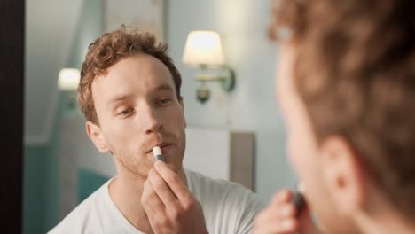 Porträt-Im-Spiegel-Eines-Jungen-Mannes-Mit-Hygienischem-Lippenstift