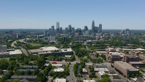 Drone-Flies-Away-from-Downtown-Charlotte,-North-Carolina-on-Hot-Summer-Day