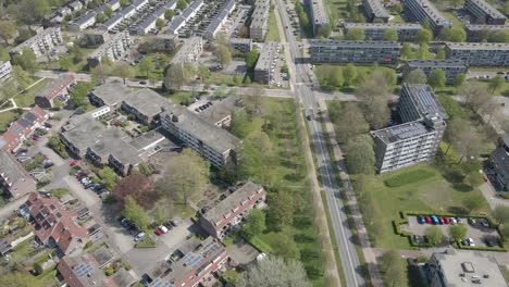 Aerial-of-small-suburban-neighborhood-next-to-long,-calm-road