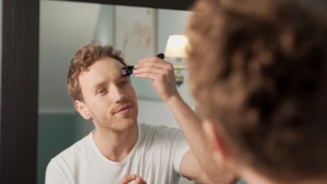 Portrait-of-a-young-man-in-the-mirror-doing-makeup