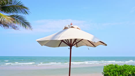 A-topical-breeze-ripples-along-the-edges-of-a-canvas-beach-shade-umbrella