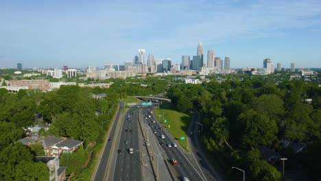 Static-Aerial-Shot-of-Cars-Driving-on-Highway,-Charlotte-Skyline-in-Background